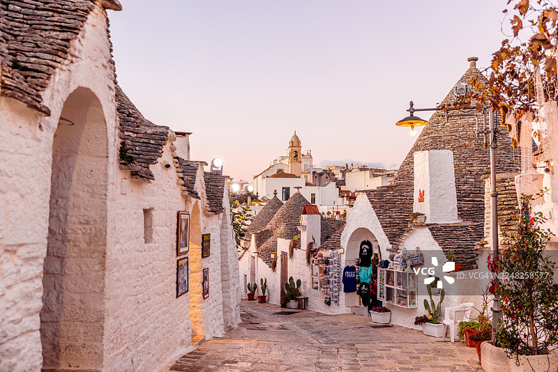意大利普利亚大区阿尔贝罗贝洛，日落时分迷人的街景，传统特鲁利房屋图片素材