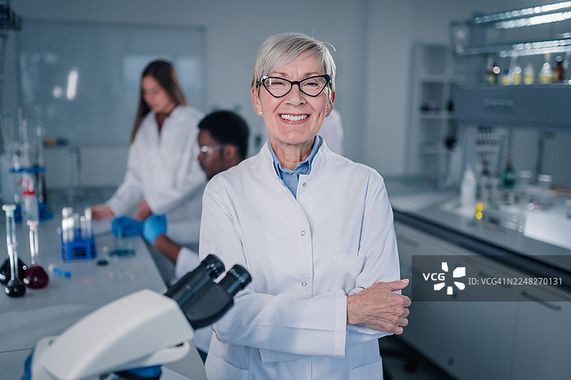 一位年长的女科学家在实验室里研究时面带微笑图片素材