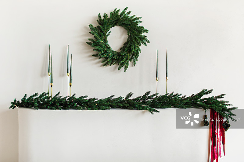 节日壁炉装饰，包括圣诞季的绿植花环、松枝、花圈和蜡烛图片素材