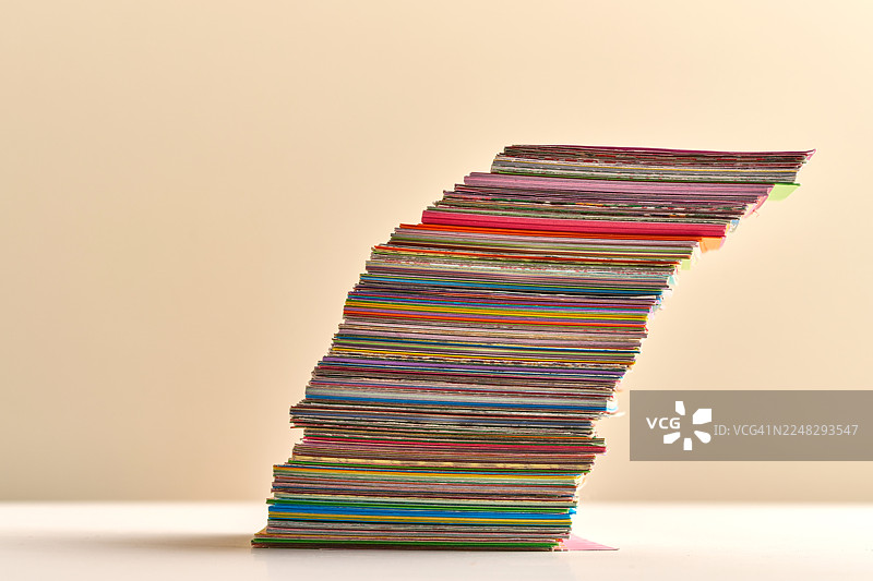 脆弱的平衡：彩色纸堆在自身重量下弯曲图片素材