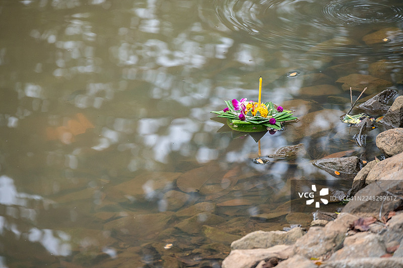 水灯卡在岩石上，成为泰国水灯节后的垃圾。水灯确实是垃圾，因为这个节日会产生大量污染水体的废物。图片素材