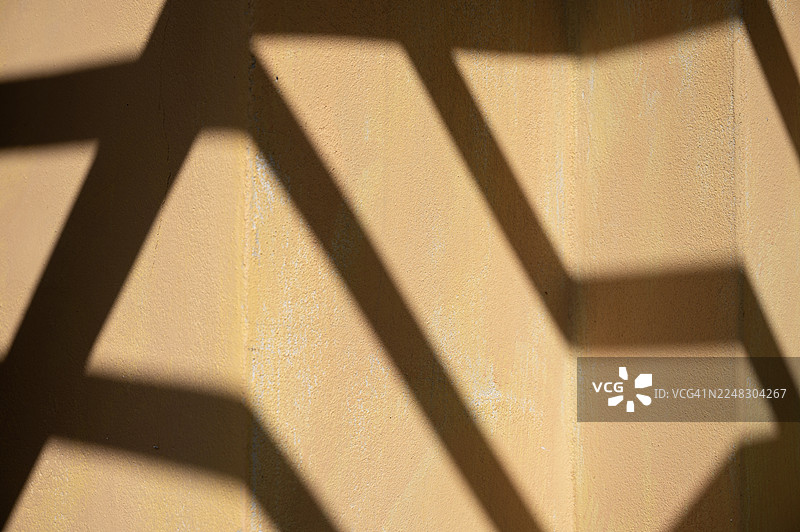 剥落的墙壁上投射着抽象的阴影图片素材