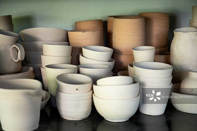 未上釉的陶碗和陶杯叠放的集合。图片素材