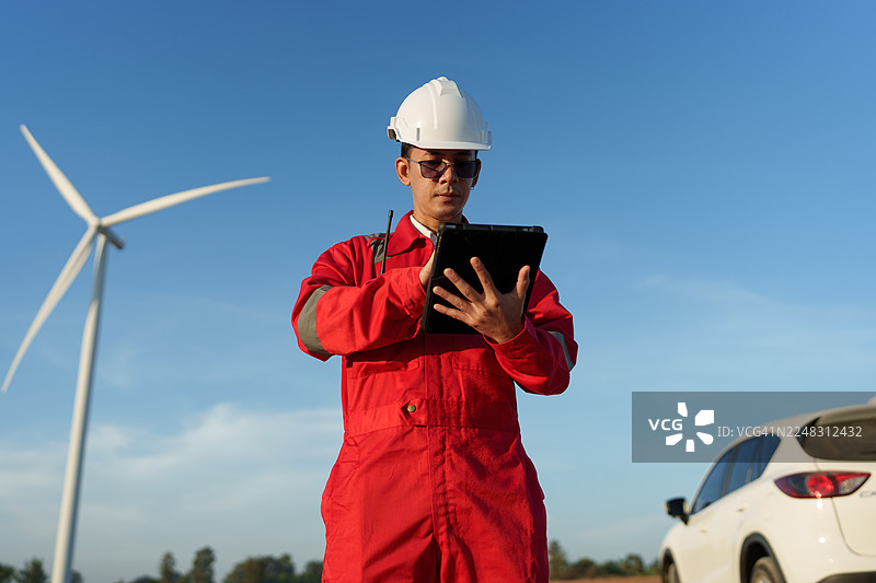 工程技术人员正在风电场检查风力涡轮机的运行并检测电力。图片素材