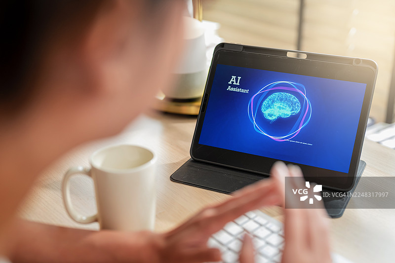 特写：女性用智能手机和平板电脑与人工智能虚拟助手互动，显示屏上展示智能技术，在家中通过无缝的数字智能管理任务图片素材