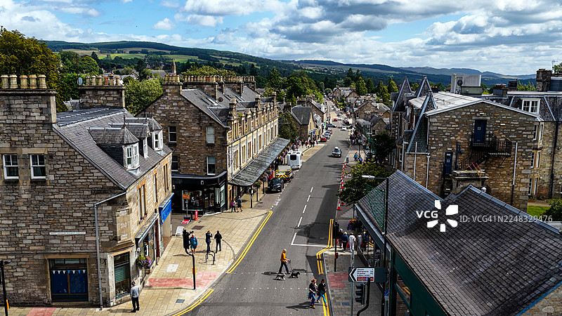 苏格兰高地皮特洛赫里镇中心航拍图，有传统的石头建筑和繁忙的主街，风景如画的定居点被绿色山丘和森林环绕，旅行与文化概念图片素材