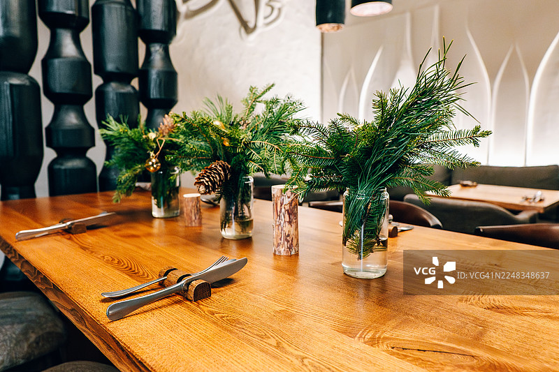 节日圣诞松枝装饰的餐厅餐桌布置图片素材