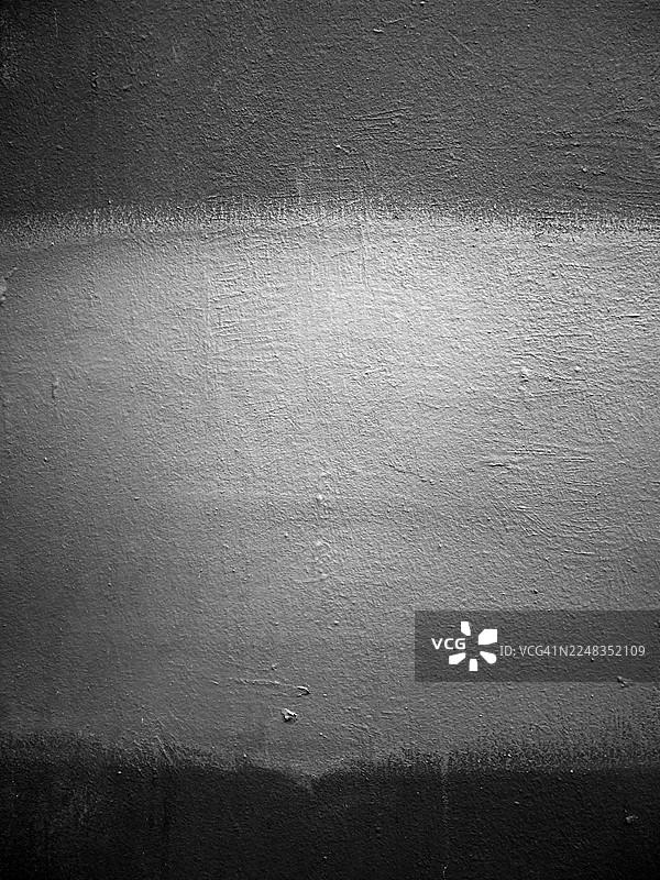 一堵粉刷成黑白灰的水泥墙，带有阴影、阳光和粗糙的纹理。法国巴黎。图片素材