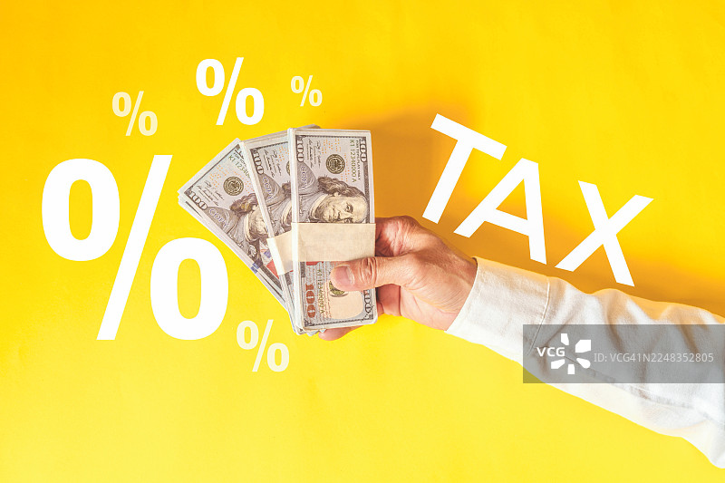 木块上写着“税务”的文字和叠放的硬币，税务概念图片素材