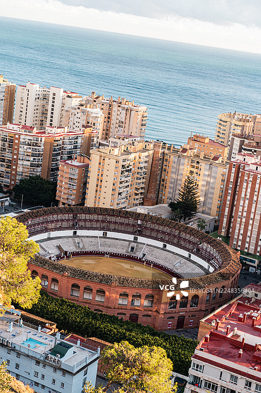 西班牙马拉加高楼大厦与大海环绕的圆形斗牛场鸟瞰图图片素材
