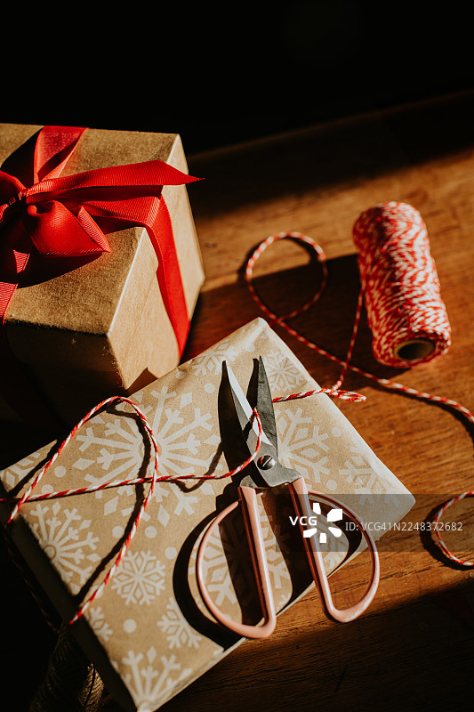 俯视角度拍摄的圣诞礼物，用包装纸和红白麻绳精心包裹图片素材