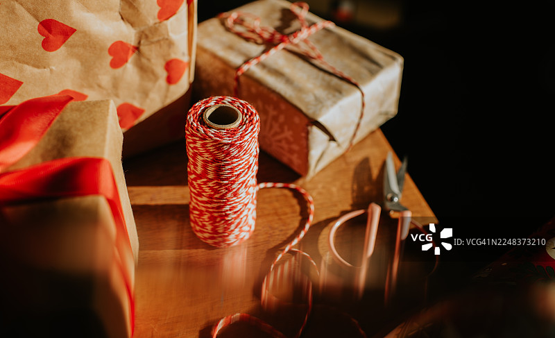包装圣诞礼物后，红色和白色麻绳在剪刀旁边图片素材