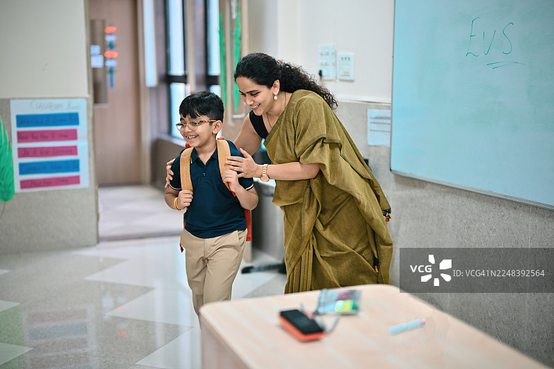 快乐的老师在教室里指导一名年轻的学生图片素材