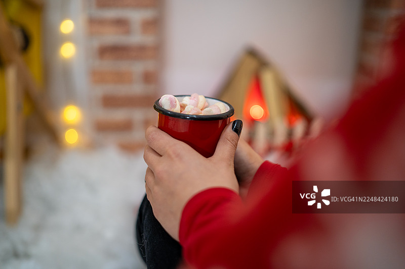 一个人在家壁炉旁享用一杯热咖啡或热茶图片素材