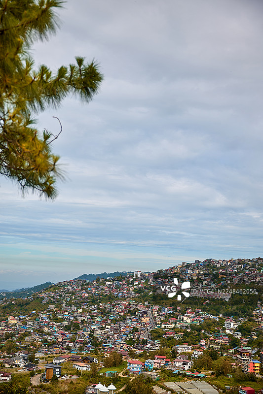 多云天空下的山坡小镇风景图片素材