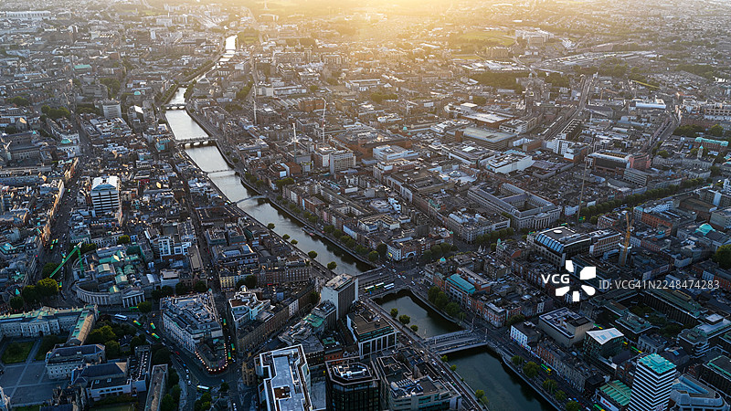 都柏林城市日落空中鸟瞰，利菲河与历史悠久的桥梁，滨水区现代与古典建筑的城市天际线，旅游和社论概念图片素材