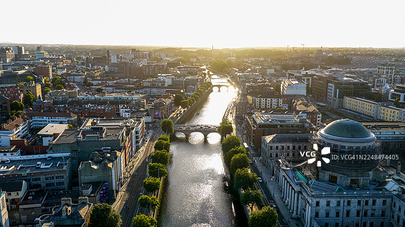 日落时都柏林城市鸟瞰图，有莉菲河、桥梁和四法院圆顶，爱尔兰首都的城市天际线，融合历史与现代建筑，适合编辑和旅游用途的旅行与城市风光概念图片素材