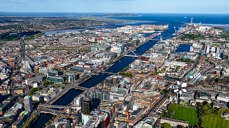 都柏林城市空中全景，有莉菲河、桥梁和都柏林港延伸至海面，城市天际线融合了爱尔兰首都的历史与现代建筑，适合旅游和媒体用途的城市景观概念图片素材