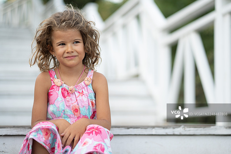 穿着夏日连衣裙的年轻女孩在户外微笑图片素材