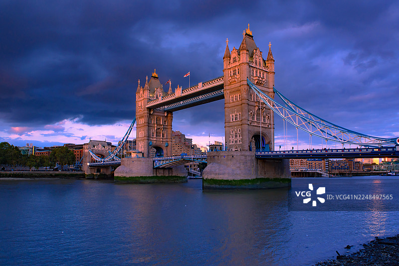 伦敦标志性地标伦敦塔桥横跨泰晤士河，在浪漫时刻被捕捉。优雅的结构在水面上被照亮。图片素材
