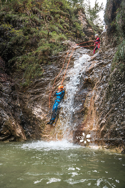 中年白人女性在峡谷壁上滑行图片素材