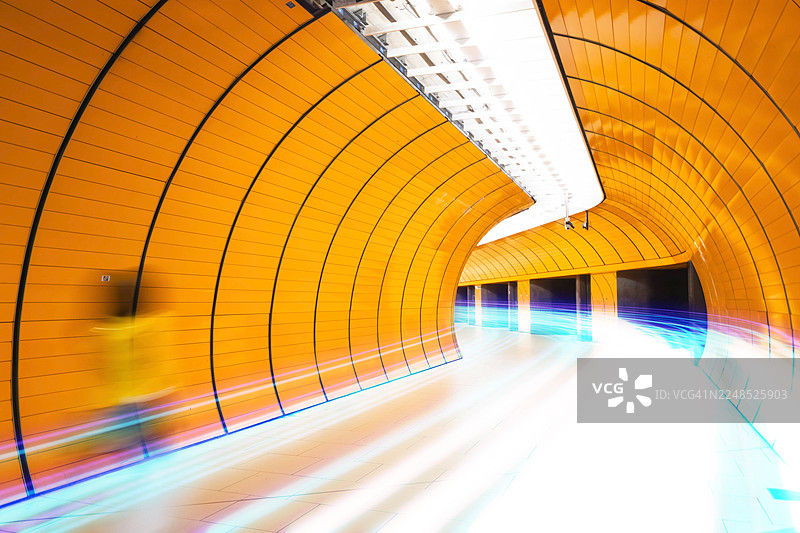 未来感橙色地下隧道中的高速光轨动态流动图片素材