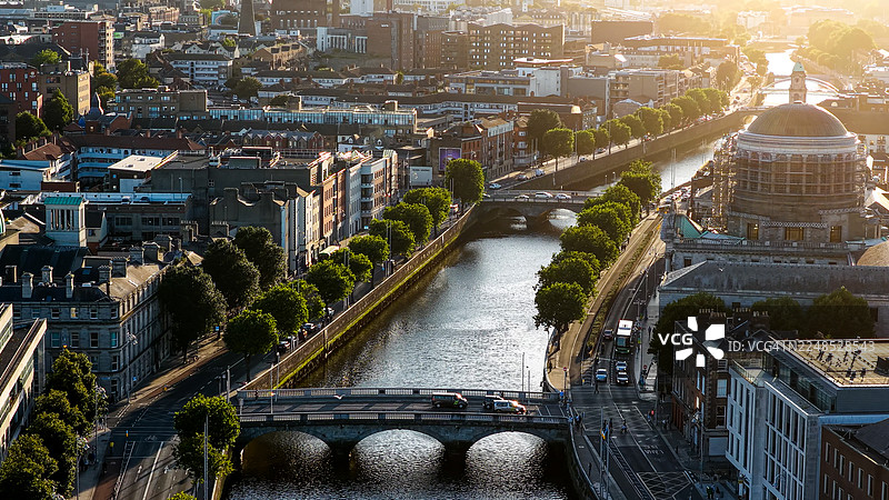 日落时分都柏林城市航拍，可见利菲河、桥梁和四法院圆顶，爱尔兰首都的城市天际线，融合了历史与现代建筑，适用于社论和旅游用途的旅行及城市景观概念图片素材