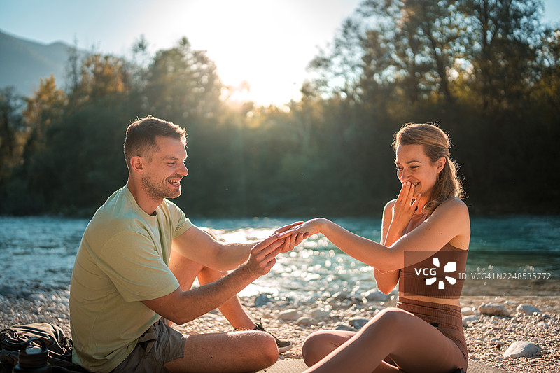 白人男性在河岸边求婚图片素材