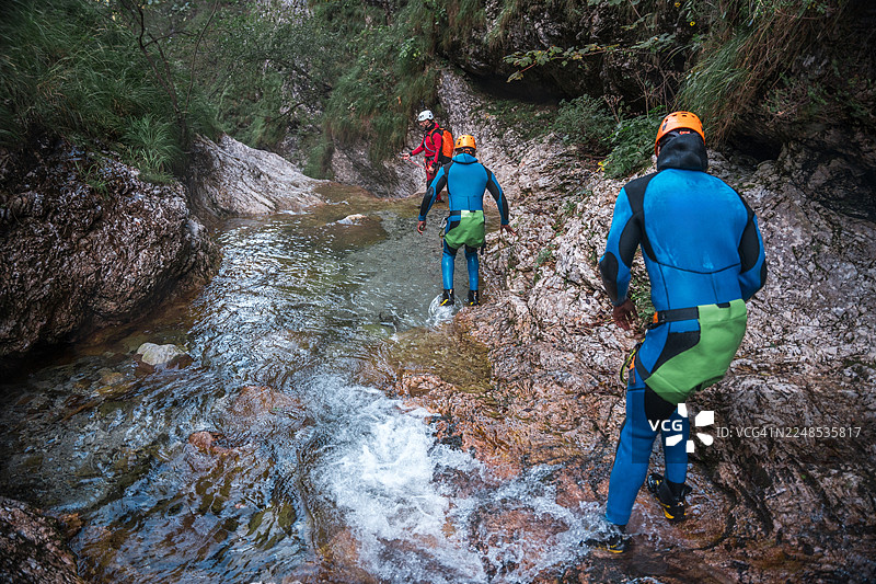 穿着氯丁橡胶服和头盔的多元化朋友在峡谷中探险图片素材
