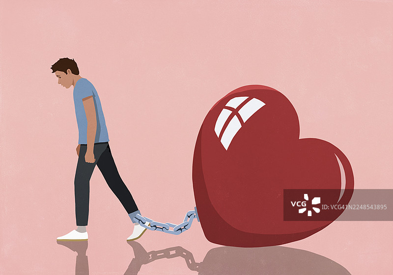 粉色背景下，被锁链拴在脚踝上的巨大红心，旁边是一位沮丧的男人图片素材