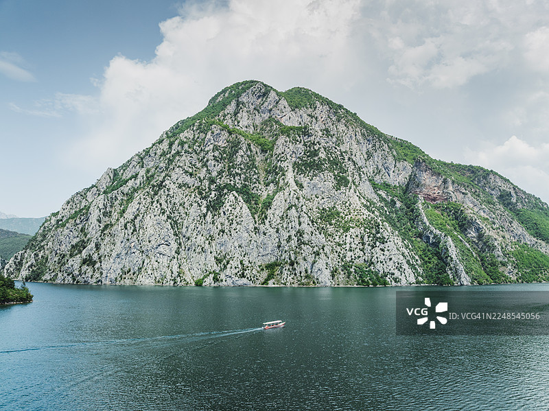 从空中视角拍摄的摩托艇在阿尔巴尼亚阿尔卑斯山科马尼湖上航行，位于阿尔巴尼亚斯库台县图片素材