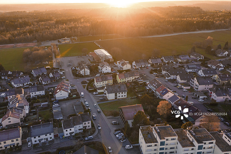 傍晚的阳光下，空中俯瞰郊区，有道路和汽车，周围环绕着自然，德国卡尔夫区阿尔滕格施泰特图片素材