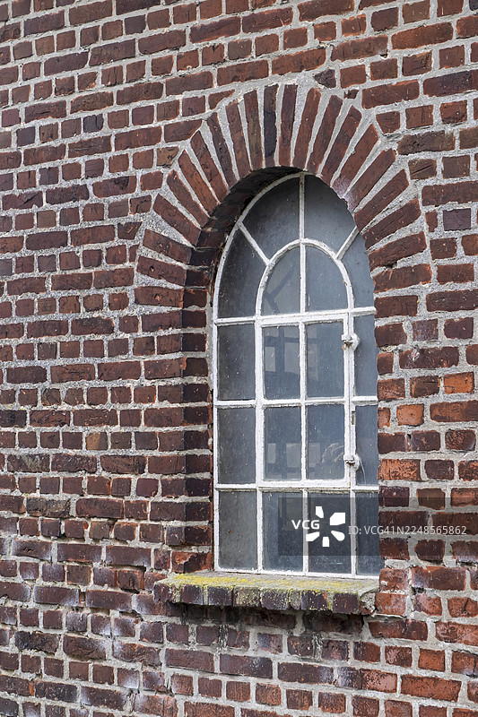一座拥有拱形窗户和质朴建筑风格的旧砖墙，位于德国北莱茵-威斯特法伦州明斯特兰的杜斯特穆勒。图片素材