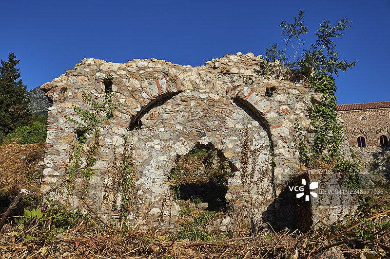 古老的石砌遗址,带有建筑拱门,长满植物,位于米斯特拉斯(米斯特拉),联合国教科文组织世界遗产地,拜占庭中世纪废弃城市,斯巴达西北部,泰格特斯山脉的山麓,伯罗奔尼撒半岛,希腊图片素材