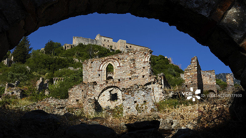 透过拱门看到的山腰遗址，位于希腊伯罗奔尼撒半岛的斯巴达西北部，塔伊盖托斯山麓的拜占庭中世纪遗址城市米斯特拉斯，被联合国教科文组织列为世界遗产。图片素材