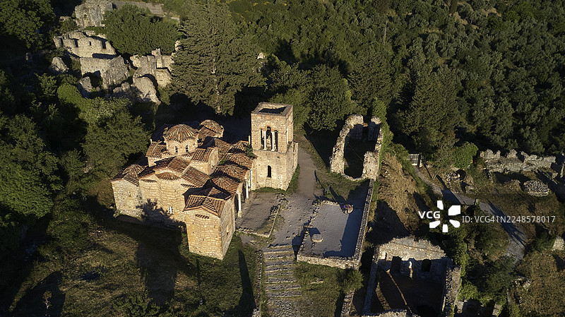 无人机视角,俯瞰中世纪拜占庭废弃古城米斯特拉斯(密斯特拉)的圣索菲亚教堂遗址,该教堂建于公元14世纪,坐落于森林之中,位于斯巴达西北部,普罗普蓬内斯半岛泰格特斯山脉的余脉,是联合国教科文组织世界文化遗产。图片素材