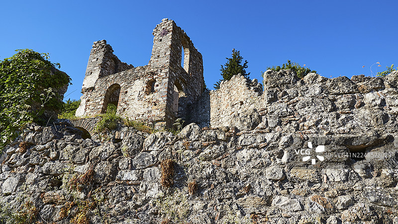 在古老的环境下，废弃的墙壁和植物在晴朗的蓝天下，位于米斯特拉斯（UNESCO世界遗产，拜占庭中世纪遗址，斯巴达西北部，泰格托斯山脉山麓，伯罗奔尼撒半岛，希腊）图片素材