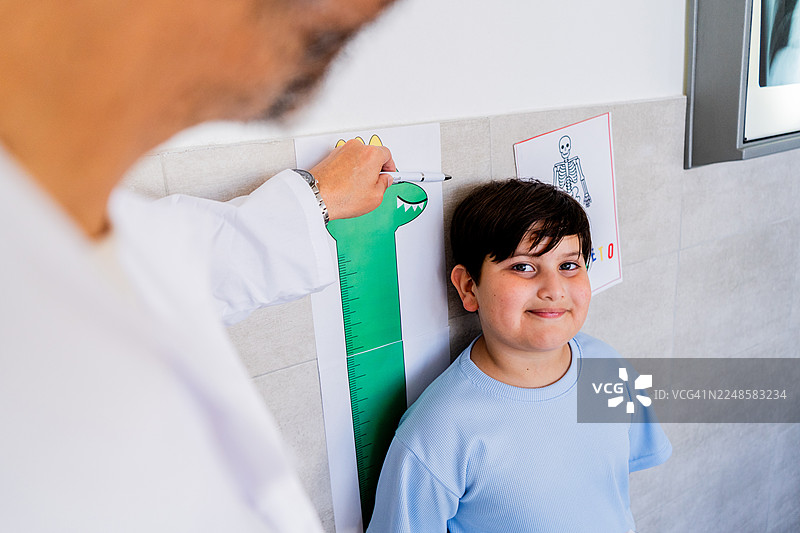 医生在医院给男孩量身高图片素材