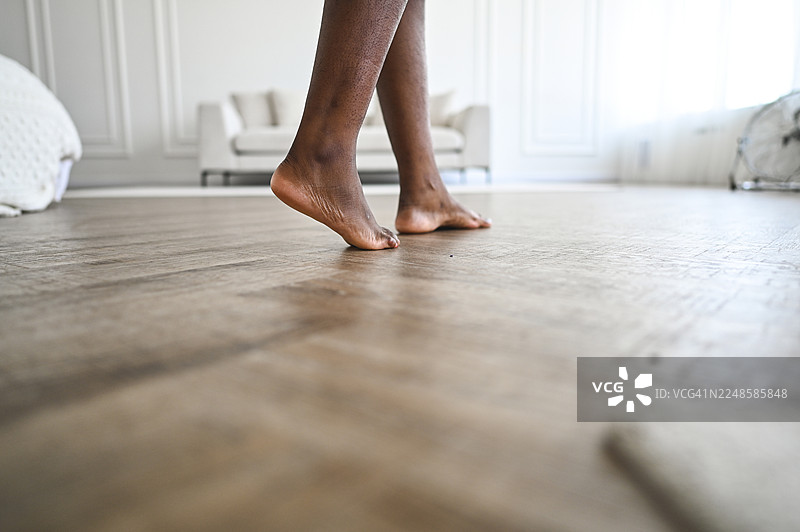 黑人赤脚走在木质公寓地板上图片素材