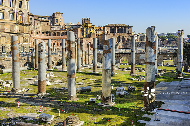 古罗马时期乌尔庇乌斯巴西利卡挖掘出的柱子和部分修复的地板景观,背景是罗马帝国广场中的图拉真广场,意大利拉齐奥罗马。图片素材