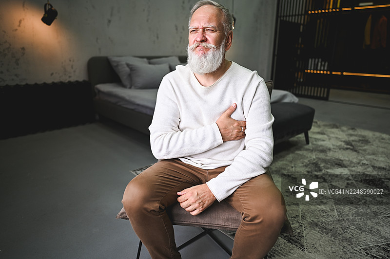 一位老年男子在家中经历胸痛图片素材