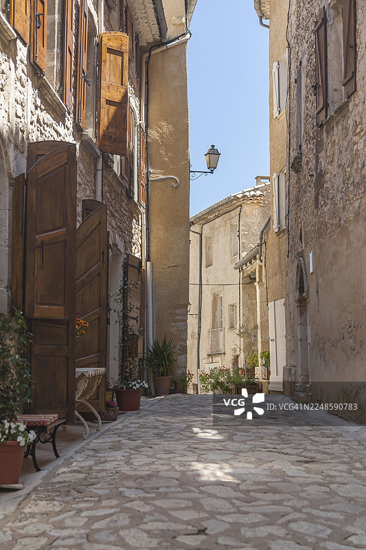法国南部普罗旺斯-阿尔卑斯-蔚蓝海岸大区沃克吕兹省奥雷勒村一条狭窄的巷子，有古老的建筑和敞开的百叶窗图片素材