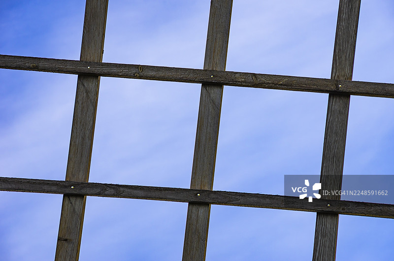 木质格栅映衬着蓝天，这是瑞典西约特兰省利德雪平附近孙纳斯堡村一处传统风车风翼的细节。图片素材