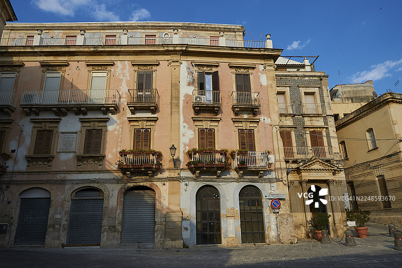 意大利西西里锡拉库扎奥提伽岛一条宁静街道上，古老建筑带有磨损的阳台和百叶窗图片素材