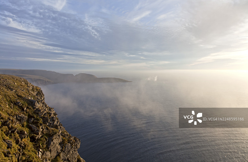 挪威北角午夜前宁静的海景与柔和的云彩图片素材
