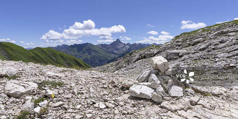 石堆,路标,科布拉特高地步道在内贝尔峰上,后面是霍赫沃格尔峰,2592米,阿尔高阿尔卑斯山,阿尔高,巴伐利亚,德国图片素材