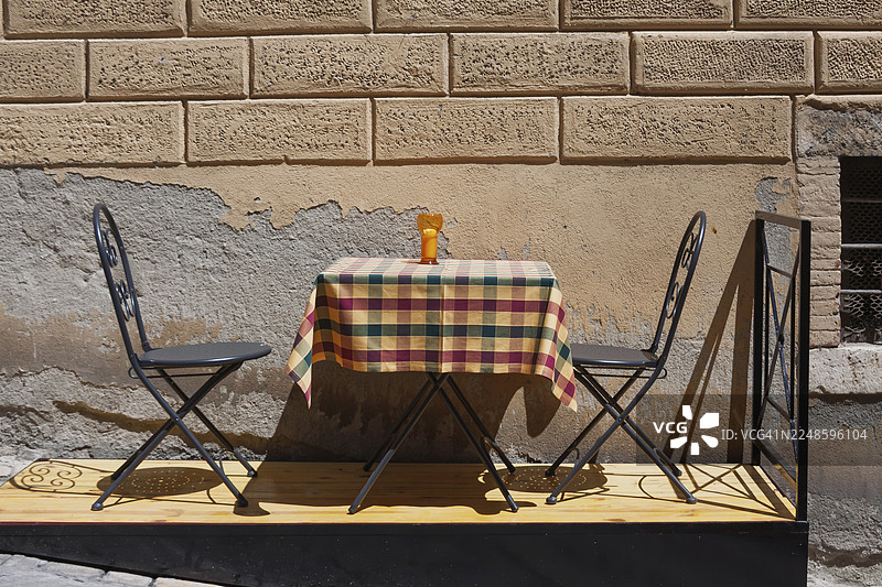 意大利锡耶纳省蒙特普尔恰诺一家咖啡馆前街上的小桌子和两把椅子图片素材