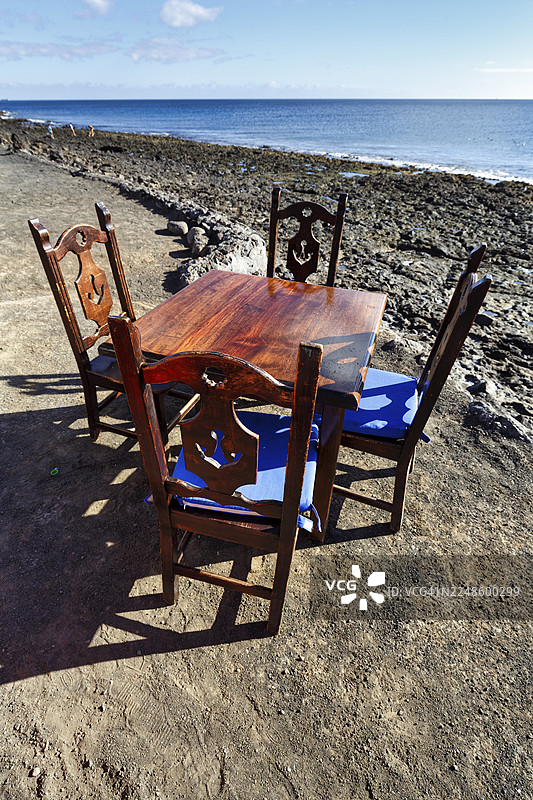 海滩上的鱼餐厅，兰萨罗特岛亚伊萨普拉亚奎马达的木桌和四把椅子图片素材