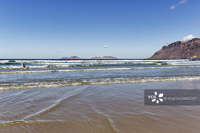 法马拉海滩，地平线上的拉格拉西奥萨岛，法马拉卡莱塔，兰萨罗特，西班牙图片素材