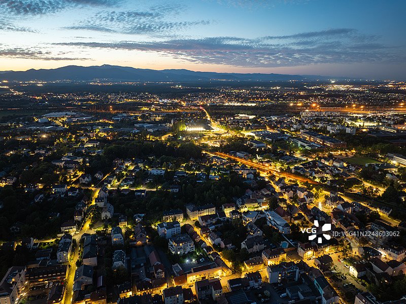 俯瞰夜间灯火辉煌的城市，天空壮丽，远山朦胧图片素材